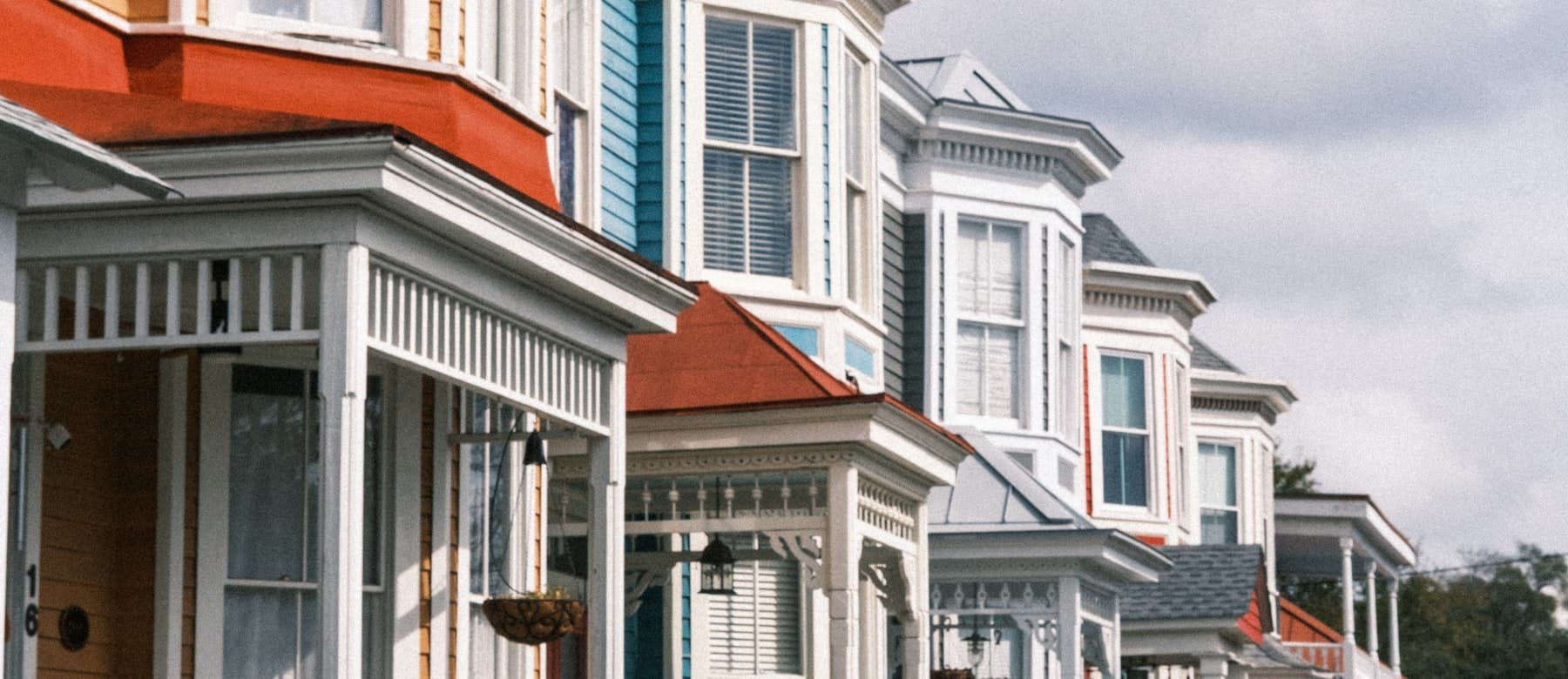 A row of houses with covered front porches running down a block