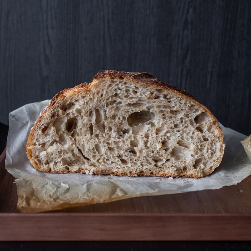 A round sourdough loaf on a wooden table