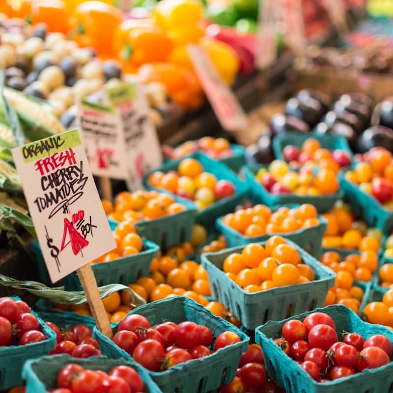Tomatoes stacked in baskets on a market table